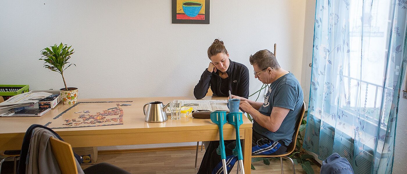 Patient, der sich beschäftigt, im Aufenthaltsraum mit einer Pflegerin