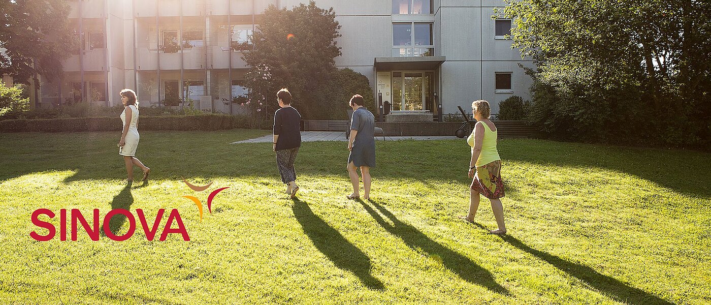 Vier Personen laufen barfuß auf einer Wiese